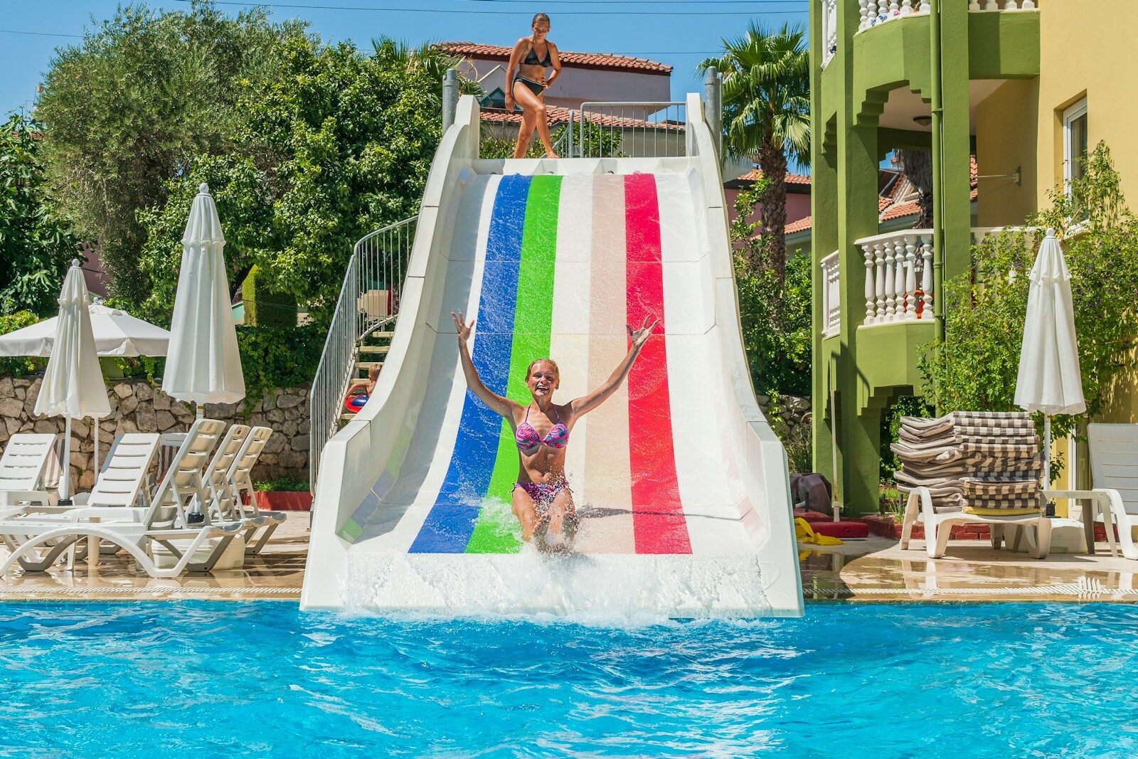 a woman on a water slide in a pool